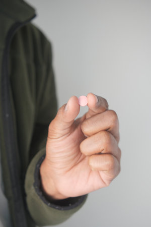 Person holding a small pink tablet in their hand indoorsの写真素材