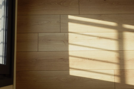 Sunlight casting shadows on wooden floor in a quiet roomの写真素材