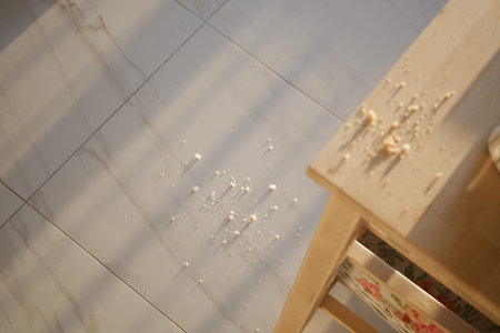 Messy Floor With Crumbs By Wooden Table Creates Casual Home Kitchen Sceneの写真素材