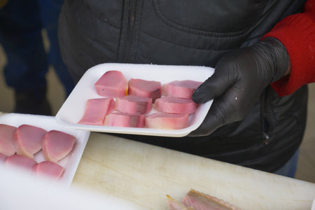 Preparing meat samples for tasting at a local eventの写真素材