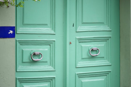 Vibrant green doors with unique handles in a lively area