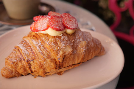Delicious croissant topped with strawberries and cream