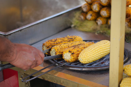 Grilling corn on a street vendors cart in warm sunlightの写真素材