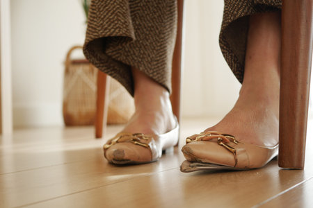 Damage Sandals on Woman Feet in Indoor Home Settingの写真素材