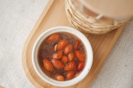 Almonds soaking in water on a wooden trayの写真素材