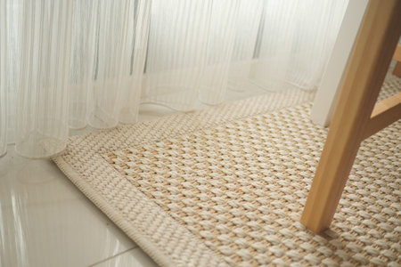 Simple woven rug under a chair by a window