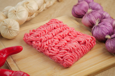 Ground meat with veggies and herbs on a board