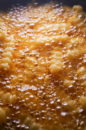 Fried dough bubbling in hot oil at a food stallの写真素材