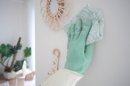 Cleaning a wall with a cloth in a bright space