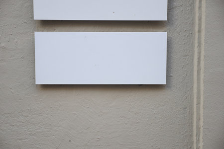 Empty white sign on a textured wall in an urban areaの写真素材