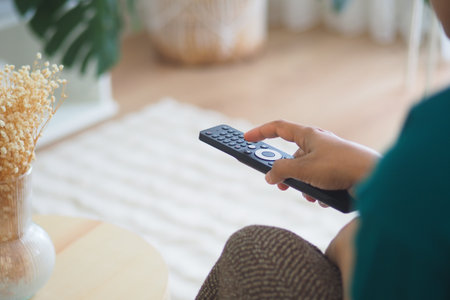 Enjoying a relaxing evening at home with a remote controlの写真素材