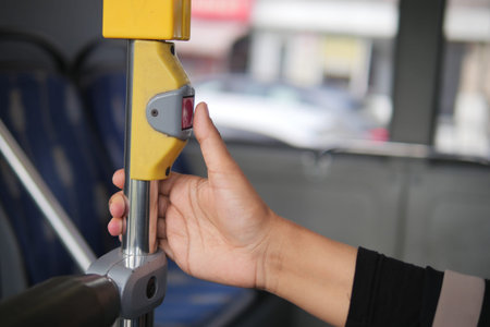 Passenger pressing button for bus stop request in city
