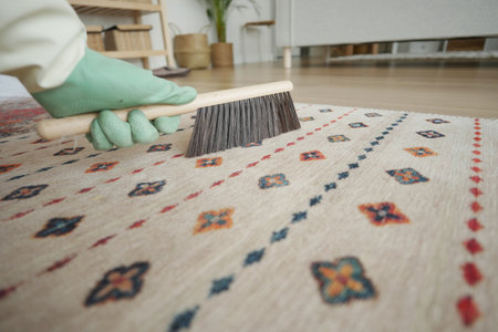 Hand cleaning a decorative carpet with a brush indoorsの写真素材