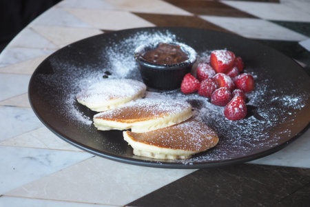 Pancakes with chocolate and strawberries at cafe