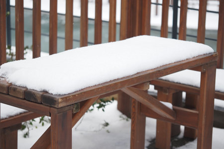 Snow-covered wooden table in a winter settingの写真素材