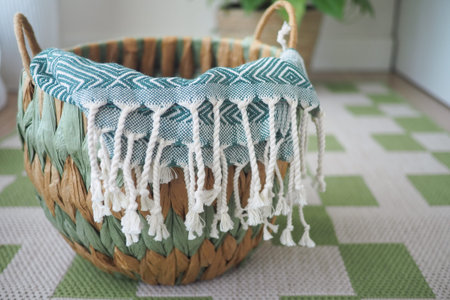 Woven basket with decorative textile on a patterned floorの写真素材