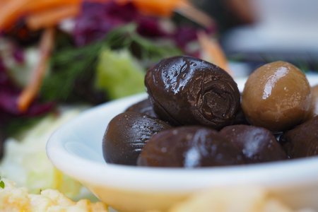 Olives served on a plate with colorful saladの写真素材