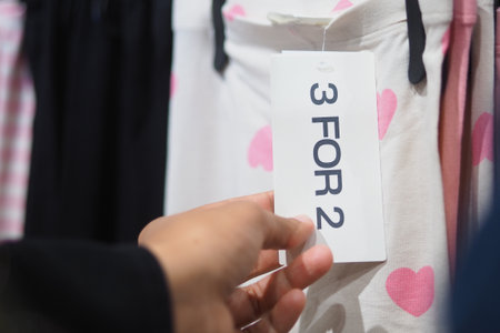 Special offer on clothing with tags displayed in storeの写真素材