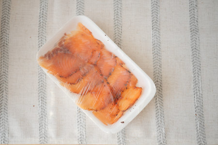 Sliced smoked salmon on a white platterの写真素材