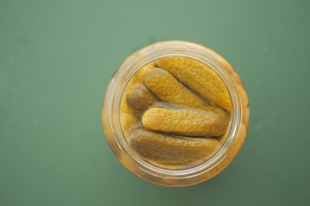 Pickles in a jar on a green backgroundの写真素材
