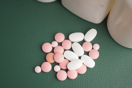 Different types of pills displayed on a green surfaceの写真素材