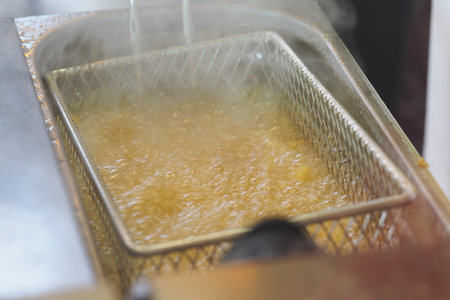 Deep frying process at a busy kitchen during lunchtime rushの写真素材