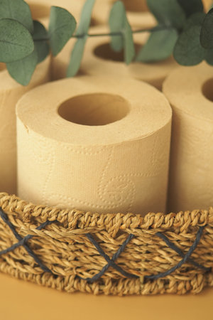 Rolled paper towels in a woven basket with greeneryの写真素材