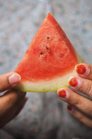 Enjoying fresh watermelon slice in sunny gardenの写真素材