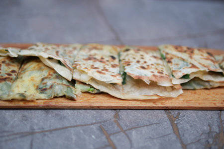 Freshly made flatbreads served on a wooden boardの写真素材