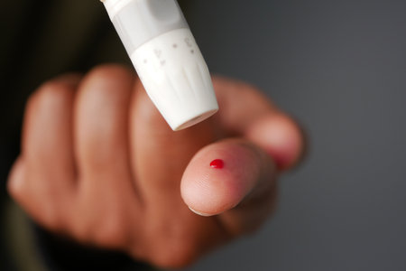 a young man using blood sugar test on fingerの写真素材