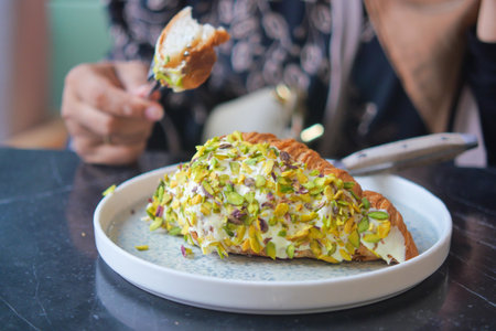 croissant topped with pistachios served at a cafeの写真素材