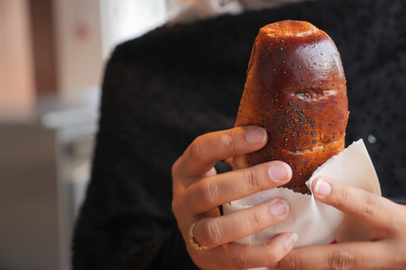 Freshly baked pastry held by a person in a cozy settingの写真素材