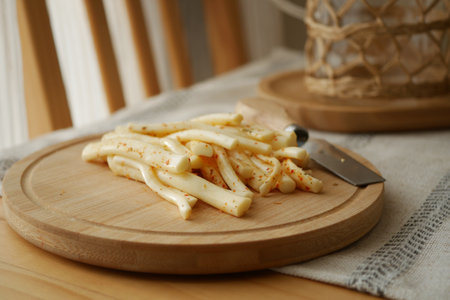 Freshly sliced cheese on a wooden cutting boardの写真素材
