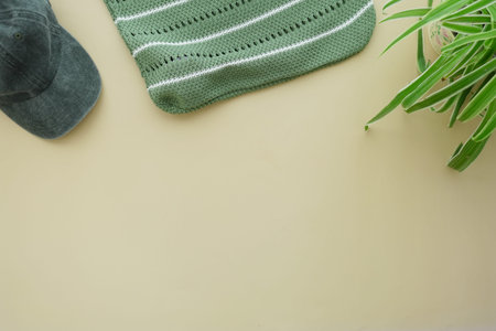 Green hat and knitted blanket on a beige surfaceの写真素材