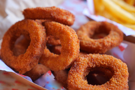 Crispy fried onion rings served in a takeout boxの写真素材