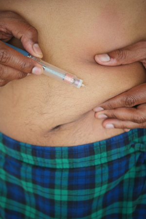 man making injection of insulin in his belly
