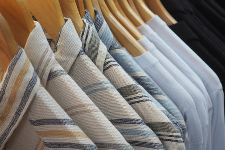Stylish shirts hanging on wooden hangers at a clothing store