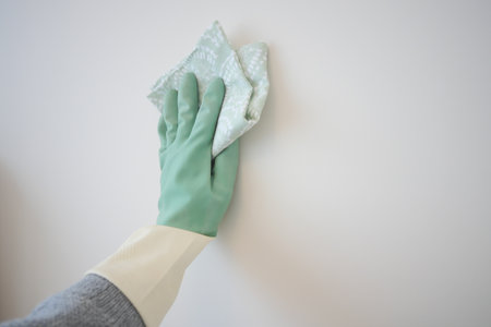 Cleaning a wall with a cloth in a light roomの写真素材