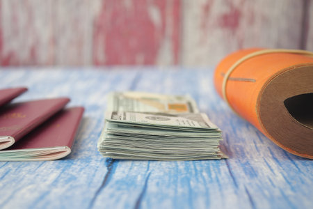Passports, a stack of cash, and a travel journal are neatly arrangedの写真素材