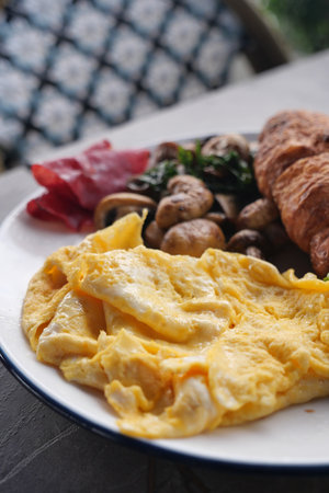 Tasty breakfast: eggs, croissant, and veggiesの写真素材