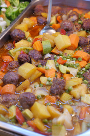 Hearty vegetable stew with meatballs in a serving trayの写真素材