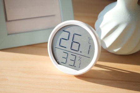 Indoor temperature and humidity display on wooden tableの写真素材