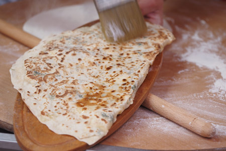 Cooking flatbread on a wooden board in a busy kitchen