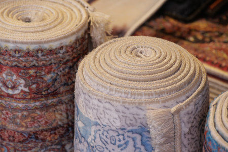 Colorful rolled rugs displayed in a market settingの写真素材