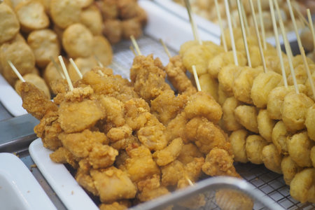 Delicious skewers of fried chicken and meatballs at a marketの写真素材