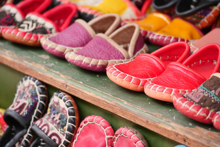Colorful handcrafted shoes displayed at a market stallの写真素材