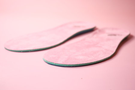 Pink shoe insoles displayed on a smooth surfaceの写真素材