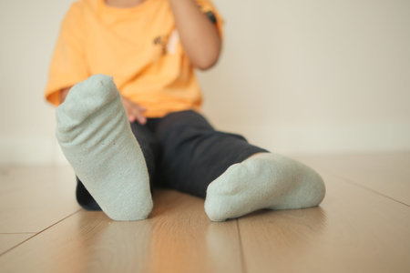 Child playing on wooden floor with fuzzy socks