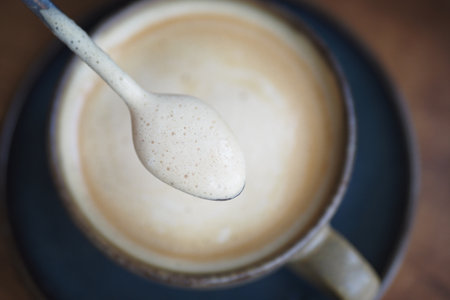 Creamy beverage served in a rustic cup at a cozy cafeの写真素材