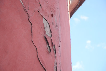 Cracked pink wall revealing layers of texture and historyの写真素材